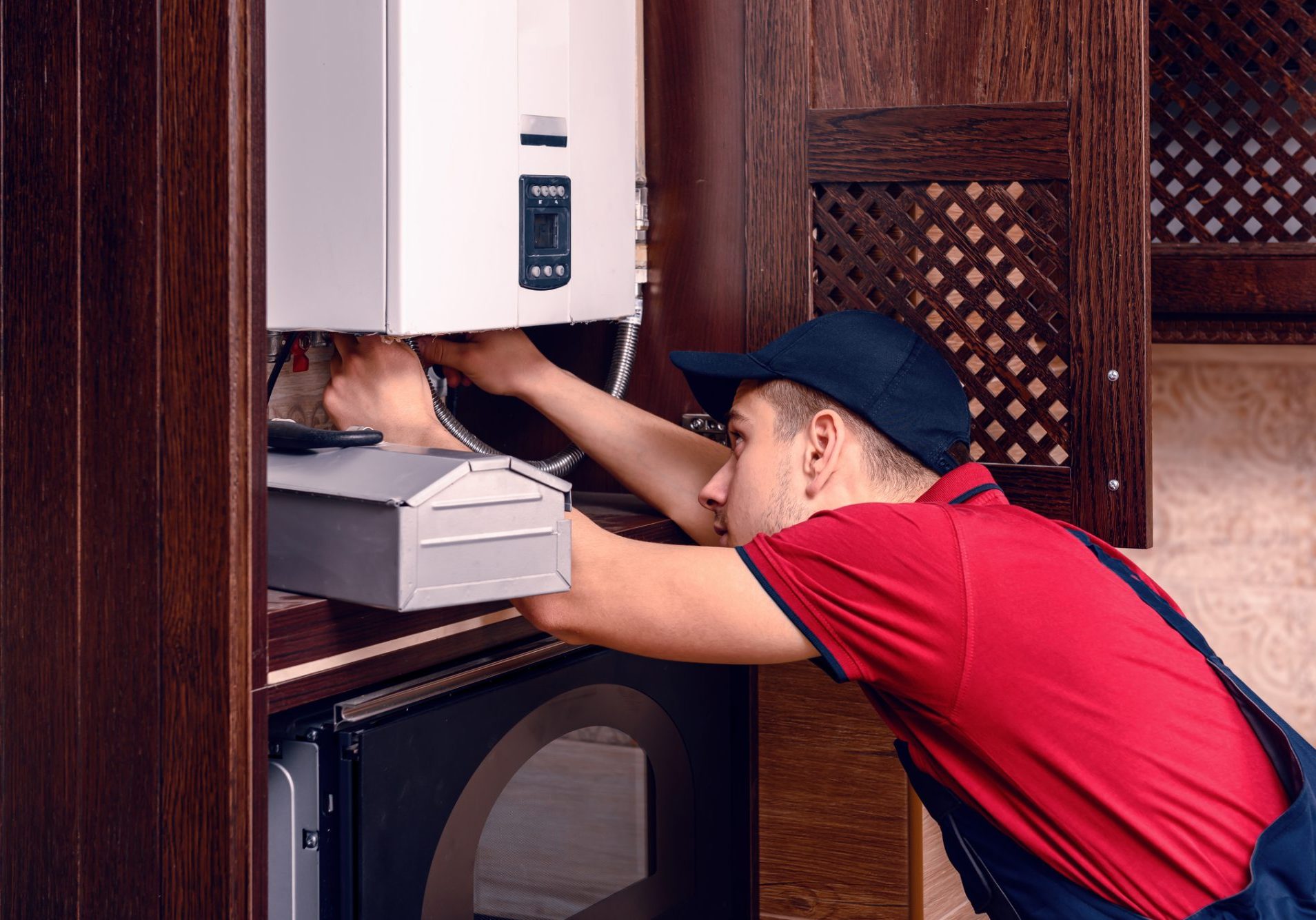 .A young skilled worker regulates the gas boiler before use